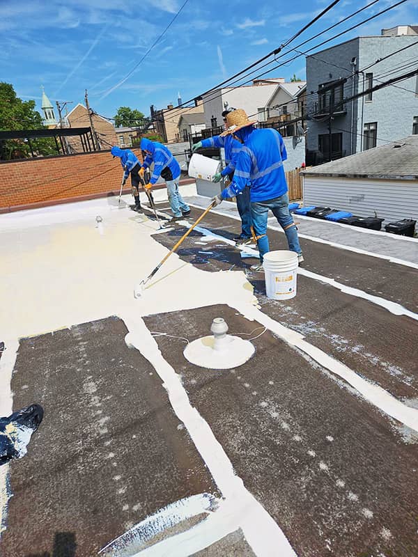 SLOG Group roof coating crew applying castagra on a flat roof